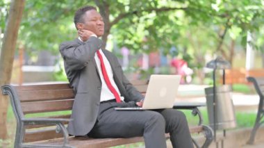 Afrikalı İşadamı kucağında dizüstü bilgisayarla Boyun Ağrısı çekiyor