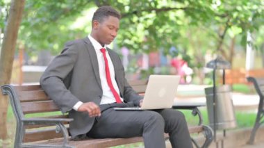Afrikalı İşadamı kucağında dizüstü bilgisayarla sırt ağrısı çekiyor