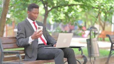 Afrikalı Adam Laptop 'u açık havada kullanıyor.