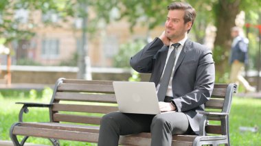 Boyun Ağrısı olan orta yaşlı iş adamı Laptop kullanıyor.