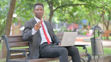 Afrikalı İşadamı kucağında laptopla İnkâr 'da Kameraya Bakıyor