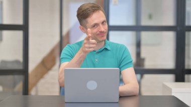 Olgun Yetişkin Adam Dizüstü bilgisayar kullanırken Kamerayı Gösteriyor