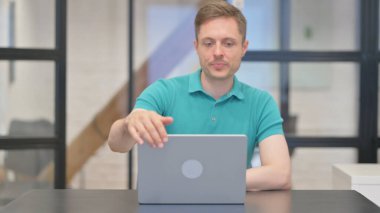 Yetişkin Adam Laptop 'ta çalıştıktan sonra ofisten ayrılıyor