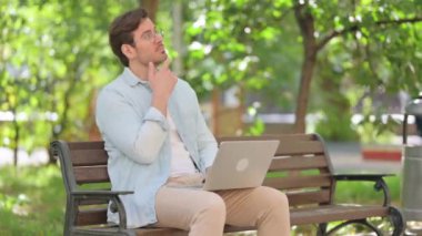 Düşünceli Orta Çağ Adamı Park 'ta otururken laptop kullanıyor
