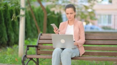 Smartphone ve Laptop üzerinde çalışan sıradan bir iş kadını.