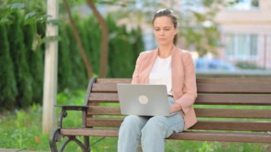 Dışarıdaki Laptop 'u kullanırken kameraya bakan sıradan iş kadını