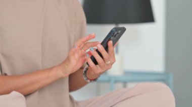 Yaşlı adam yatağın kenarında otururken akıllı telefon kullanıyor.