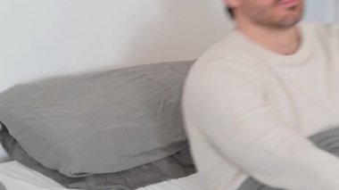 Yorgun yaşlı adam dinlenmek için yatağa uzanıyor.