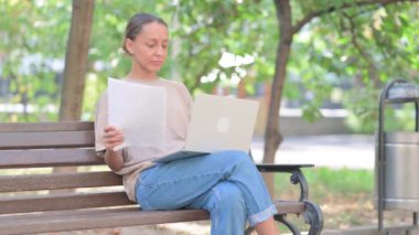 Yaşlı adam Bench 'te otururken belge okuyor.