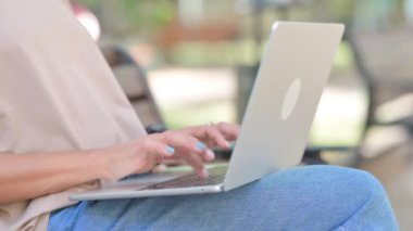 Yaşlı adam dışarıda Bench 'te otururken dizüstü bilgisayarda çalışıyor.