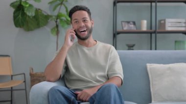 İspanyol Adam evde telefonla konuşuyor.