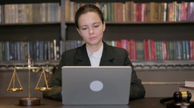 Dizüstü bilgisayarda çalışan genç bayan yargıç.