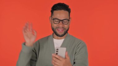 Günlük İspanyol Adam Kırmızı Arkaplanda Telefonda Video Sohbeti Yapıyor