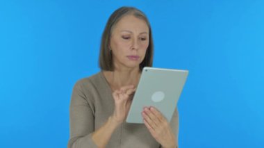 Mavi Arkaplanda Dijital Tablet Kullanan Yaşlı Kadın
