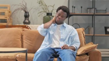 Evdeki Kanepede oturan boynu ağrıyan Afrikalı adam