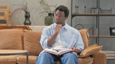 Evde otururken kitap okuyan Afrikalı Beyin Fırtınası