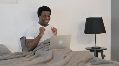 Afrikalı Adam Yatakta Otururken Dizüstü Bilgisayarda Çalışmayı Kutluyor