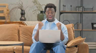 Kucağında Dizüstü bilgisayarda Afrikalı Adam Başarı Kutlaması