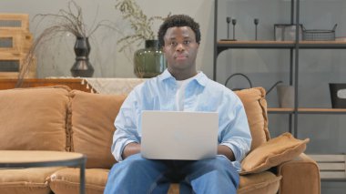 Ev Kucağında Dizüstü bilgisayarlı Ciddi Afrikalı Adam