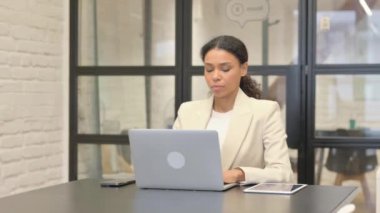 Dizüstü bilgisayar kullanan Afrikalı İş Kadınından Başparmak İndirme