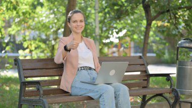 Banch 'ta dizüstü bilgisayar kullanan Genç Kadın Başparmağını kaldırdı