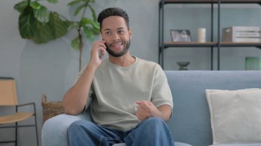 İspanyol Adam evde telefonla konuşuyor.