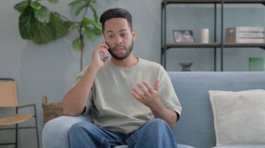 Öfkeli İspanyol Adam evde telefonla konuşuyor.