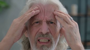 Baş ağrısı olan yaşlı adama yaklaş.