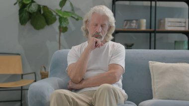 Yaşlı adam koltukta otururken uyuyor