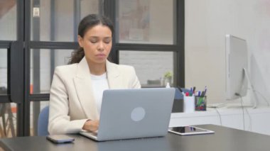 Ofiste dizüstü bilgisayarla çalışırken Afrikalı İş Kadını Kameraya Bakıyor