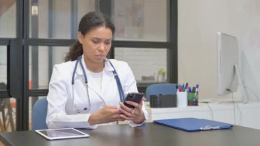 Hastanede akıllı telefon kullanan Afrikalı kadın doktor.