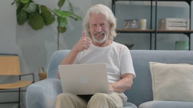 Kucağında dizüstü bilgisayarla Yaşlı Adam Başparmağını kaldırdı