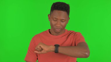 Bekleyen Afrikalı Genç Adam Yeşil Arkaplanda Zamanı Kontrol Ediyor