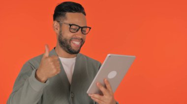 Günlük İspanyol Adam Kırmızı Arkaplanda Tablet 'te Başarı Kutlaması