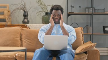 Evde Dizüstü bilgisayar kullanan Baş Ağrısı Olan Afrikalı Adam