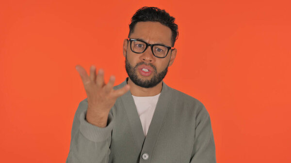 Angry Casual Hispanic Man Talking in Anger on Red Background, Portrait