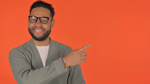 Casual Hispanic Man Showing Copyspace on Red Background