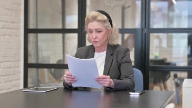 İş yerinde Evrak Okuyan Yaşlı İş Kadını