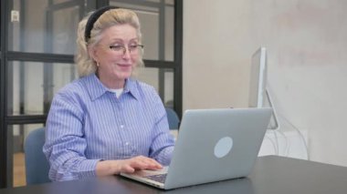 Dizüstü bilgisayarla video sohbeti yapan sıradan yaşlı kadın.