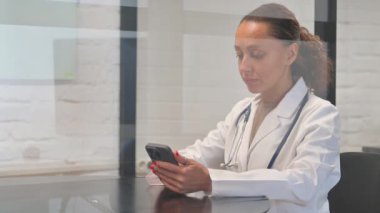 İş yerinde telefon kullanan çok ırklı kadın doktor.