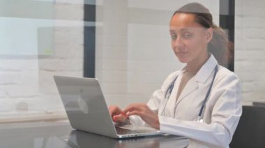 Dizüstü bilgisayar üzerinde çalışırken İnkâr Eden Çok Irklı Kadın Doktor