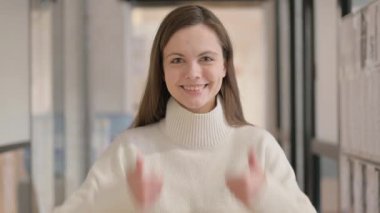 Başparmakları havada genç bir kadının portresi Kameraya bakıyor