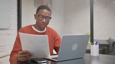 Belgeler ve dizüstü bilgisayar üzerinde çalışan afro-amerikan adam