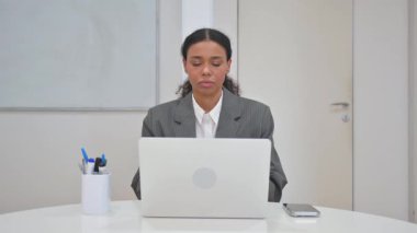 Dizüstü bilgisayarda çalışırken kameraya bakan Afrikalı İş Kadını