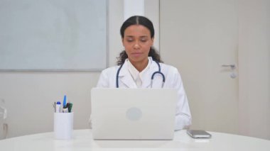 Bilgisayarda çalışırken Kameraya Bakan Afrikalı Doktor