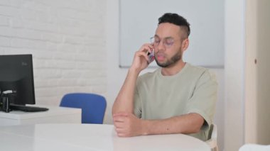 İspanyol Adam müşteriyle telefonda konuşuyor.