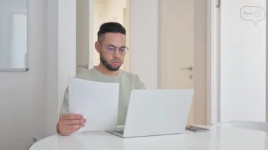 Dizüstü bilgisayarla iş raporu üzerinde çalışan orta yaşlı bir adam