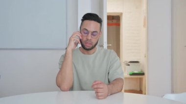 Orta yaşlı adam müşteriyle telefonda konuşuyor.