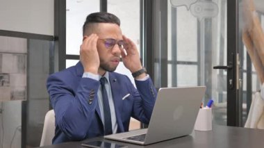 Orta yaşlı iş adamı dizüstü bilgisayar kullanırken baş ağrısı çekiyor