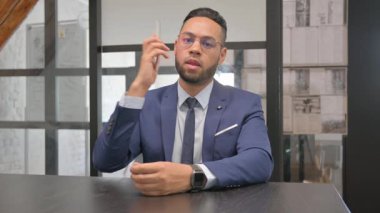 İspanyol adam İş yerinde telefonla konuşuyor.